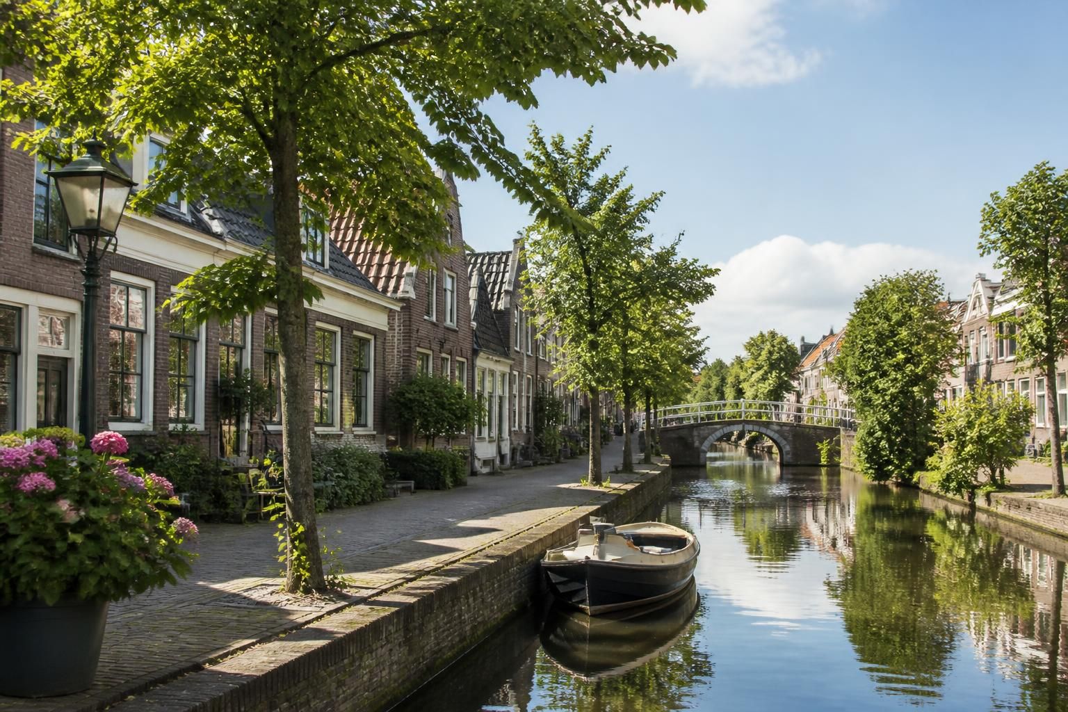 Canal-side town scene with tidy streets and greenery.